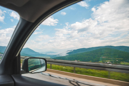 汽车旅行概念。从窗口查看。美丽的山峦，云雾，蓝天