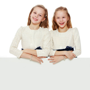 两个小女孩从白色广告禁令背后偷看出来