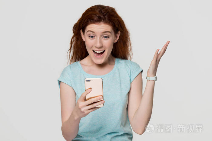 兴奋的女人拿着手机看着手机惊讶的短信