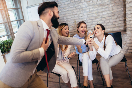 商务人员在团队建设研讨会期间进行团队培训锻炼,唱卡拉ok.