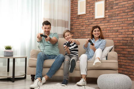 客厅沙发上玩电子游戏的幸福家庭