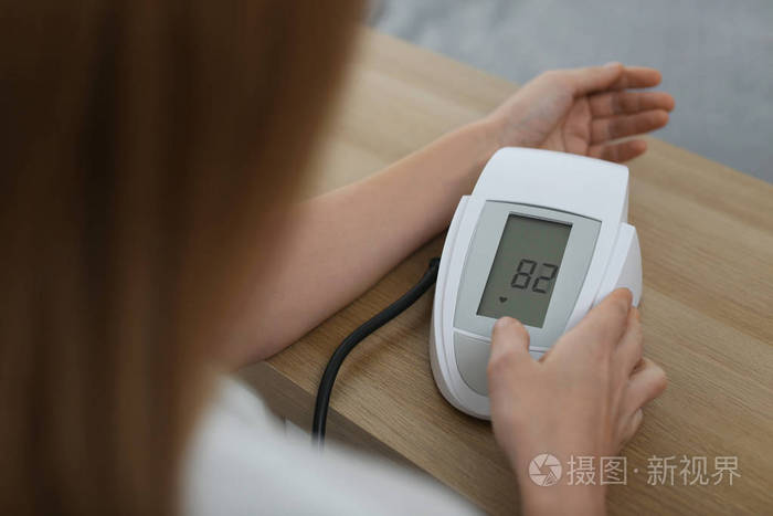 女士用血压计检查血压在室内的桌子上特写心脏学概念