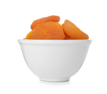 白色背景上有杏子的碗。干果作为健康食品