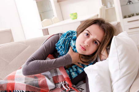 生病的年轻女子在家里受苦受难