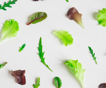 绿色沙拉叶在白色背景上。 带有生菜叶的图案。 背景设计与叶子沙拉。 带有生菜叶的图案。