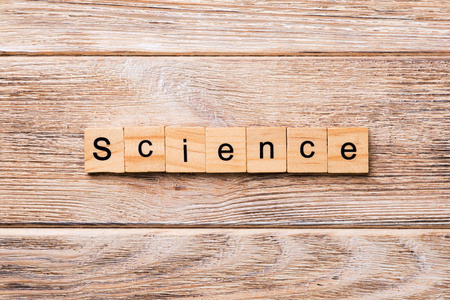 写在木块上的科学单词。 科学文本在木桌上为您的设计概念。