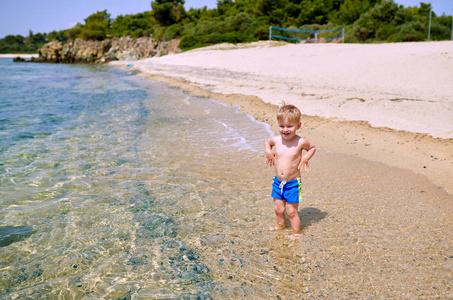 海滩上两岁蹒跚学步的男孩
