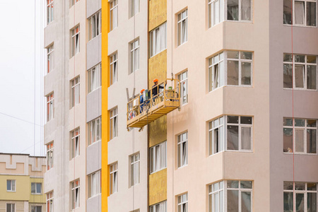 建筑商在高层住宅建筑的外墙上作画