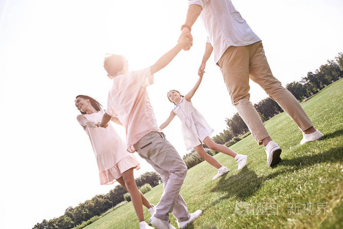 粘接四家手拉手在草地上翩翩起舞