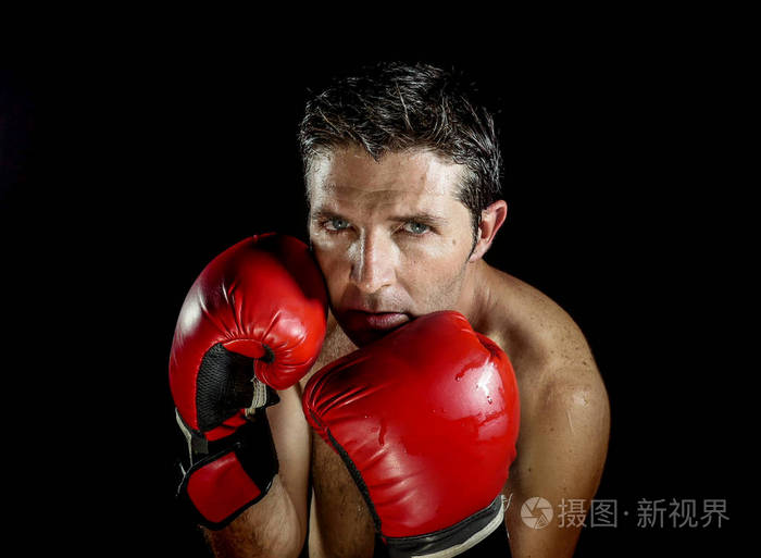年轻的愤怒和激烈的运动男子拳击手套摆姿势,坏蛋战士态度,冷静和愤怒