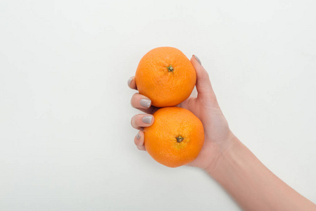 在白色背景下，女人手里拿着两整条橘子