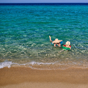 两岁的蹒跚学步的男孩和母亲在海滩上