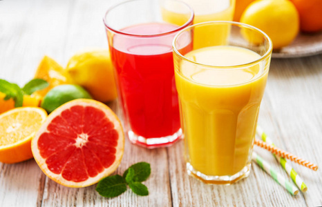 木制桌子上的一杯果汁和柑橘类水果