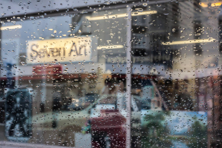 雨滴在汽车玻璃上，焦点在雨滴上。 去街景