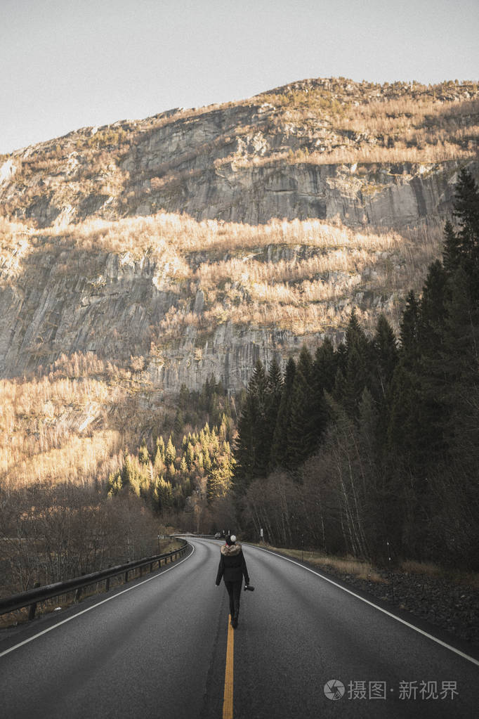 女摄影师在路上行走的后视镜