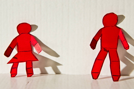 一个男人和女人站在一起的红纸人物的抽象形象。