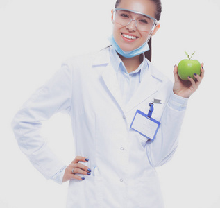 牙医医生女人在手和牙齿刷举行绿色新鲜苹果。牙科医生。一个女医生