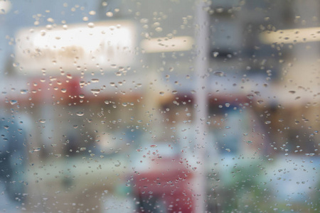 雨滴在汽车玻璃上，焦点在雨滴上。 去街景