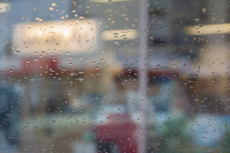 雨滴在汽车玻璃上，焦点在雨滴上。 去街景