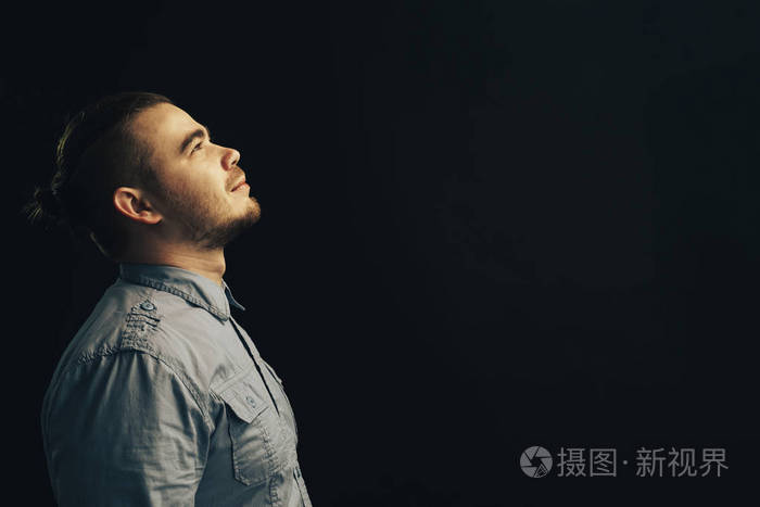 年轻人抬头看着黑色的背景.