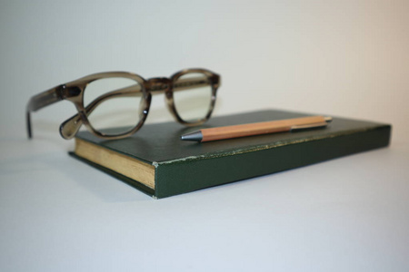 白色背景的旧书和眼镜