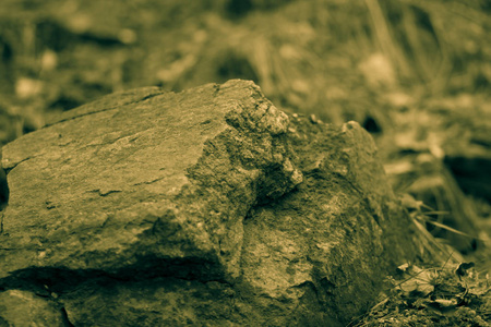 花岗岩岩石在老式调色。 花岗岩靠近。 棕色石头的纹理。 带有萼片的天然材料