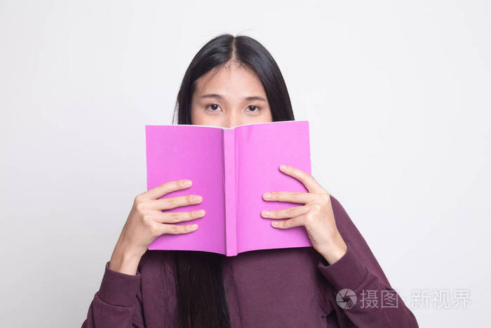 年轻的亚洲女人,带着一本书,白色背景上遮住她的脸