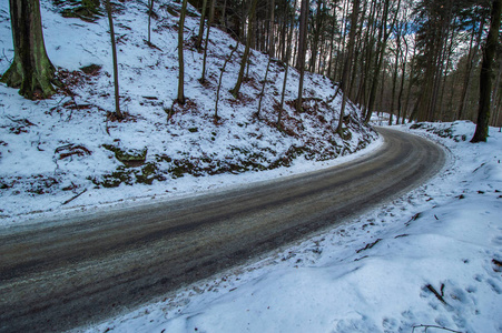 白雪皑皑的小山和光秃秃的树对乡村道路的看法