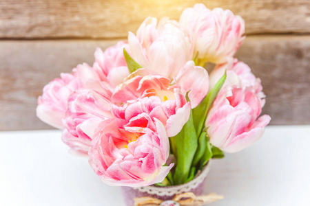 春天的贺卡。 木质背景上的一束新鲜的浅粉色郁金香花。 节日快乐复活节母亲节周年情人节生日概念。 平躺顶视复印空间