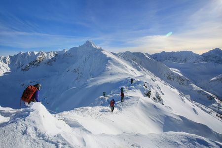 系着冰斧和头盔的绳子系着雪地爬山的登山者