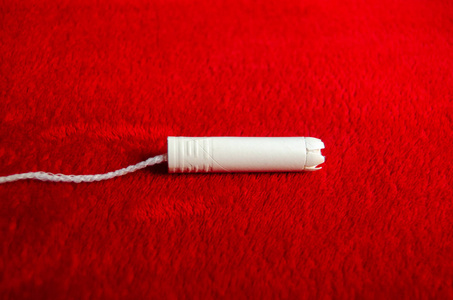 红色毛毯上的白色卫生棉，简约PMS概念