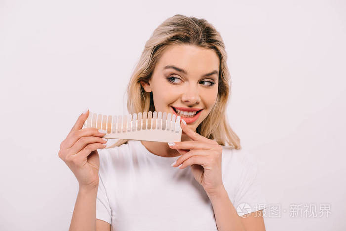 美丽的微笑女人拿着牙齿调色板隔离白牙美白的概念