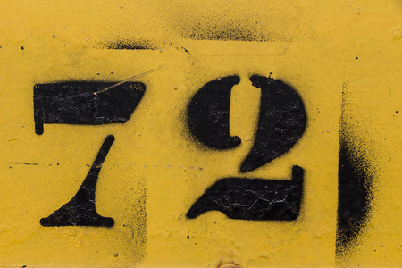 黑色数字模板涂在黄色背景上72号72号72号.照片