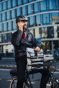 男性快递与自行车递送包在城市, 做一个电话