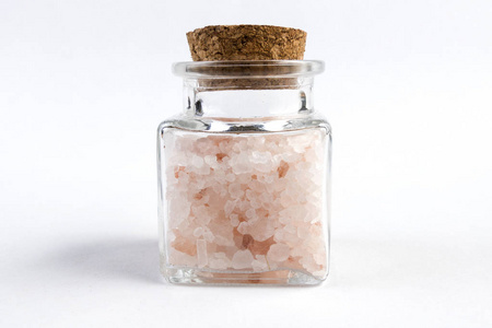 喜马拉雅山粉盐在玻璃罐中分离在白色背景上