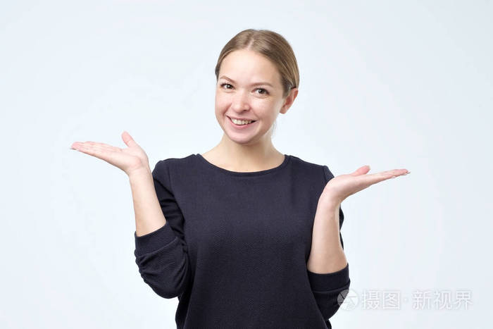 愉快的年轻女子张开双手对着镜头微笑