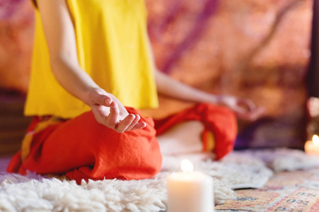 打坐室妇女手在瑜伽莲花的特写镜头在一个与蜡烛的制作室摆姿势冥想