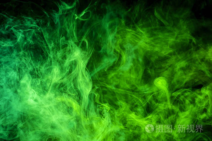 厚厚的彩色绿色烟雾在黑色的孤立背景上烟雾中的背景
