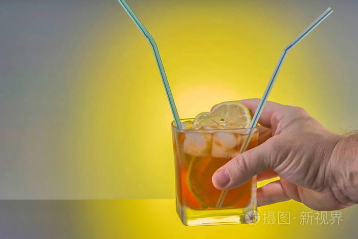 一只手拿着两个小管的鸡尾酒. 友谊,爱情和相互理解的概念