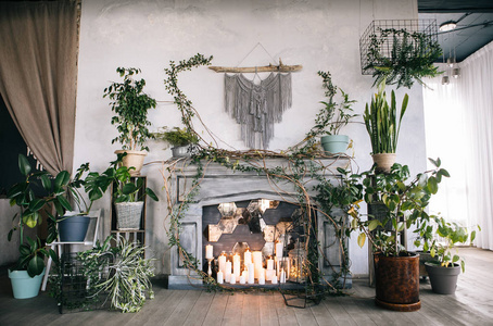 创意装饰和设计阁楼灰色壁炉蜡烛，老式扶手椅和植物