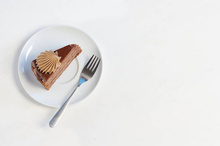 一块美味的巧克力蛋糕，在白色盘子上装饰巧克力奶油，上面有甜点叉子。 菜单样式