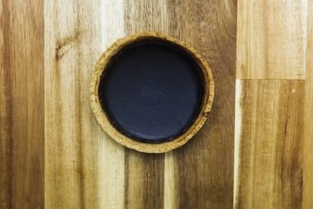 木制桌子上的甜鲜黑巧克力馅饼