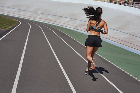 训练你的身体。球场赛道上的赛跑者。妇女夏季健身锻炼。慢跑运动健康积极的生活方式理念