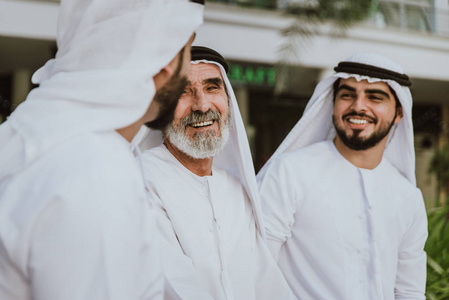 3个穿着阿联酋传统服装的商人在迪拜散步