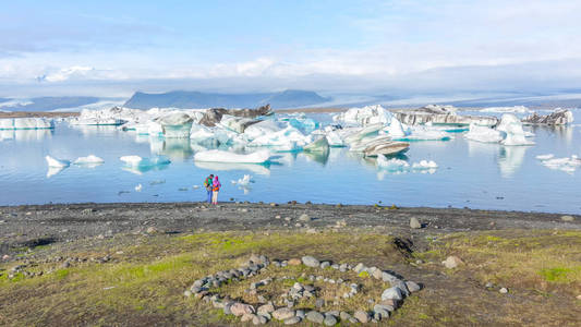 夫妇俩在冰岛的jokulsarlon冰湖欣赏冰山景色