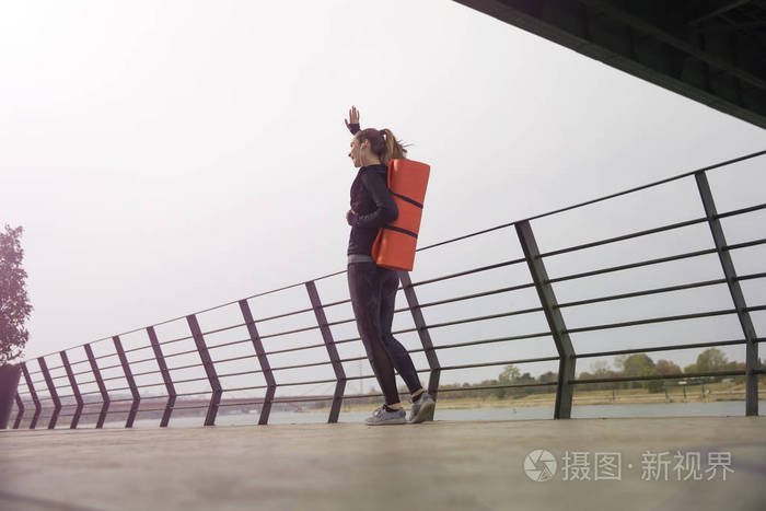 健身妇女背着垫子走路