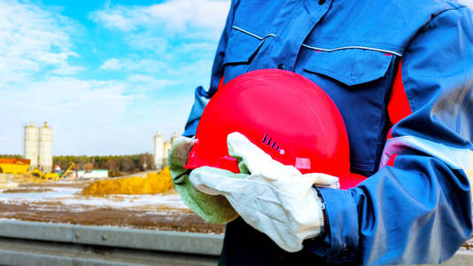 红色头盔和手套. 戴安全帽的建筑工人. 道路和公路的建造和修理照片