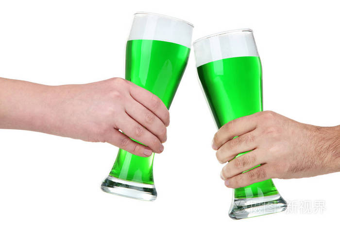 s Day. Glasses of green beer in male hands on white background