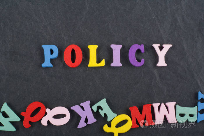 政策词在黑板背景上由彩色ABC字母组成，木块木制字母复制空间为广告文本。 学习英语