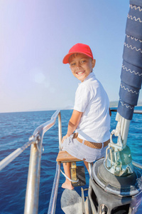 船上的小男孩在夏天乘坐游艇出海巡航。冒险旅行，家庭度假游艇与孩子